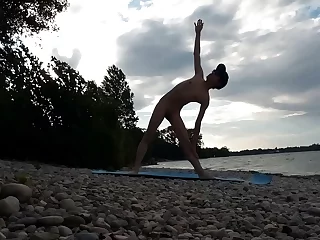 لاغر, برهنه, جان آرتین در آفتاب در یک ساحل, با شکوه تسلط یوگا شمار. این ویدیوی یوگا برهنه ، بدن پر زرق و برق و توانایی انعطاف پذیر او را نشان می دهد ، که تناسب اندام را با اشتیاق عریانی ترکیب می کند.