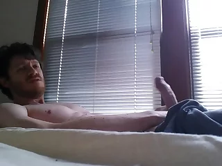 A hunky guy in sweats, by the window, indulges in self-pleasure, stroking his big dick until he blows a massive load. Witness his raw, unfiltered pleasure and intense orgasm.